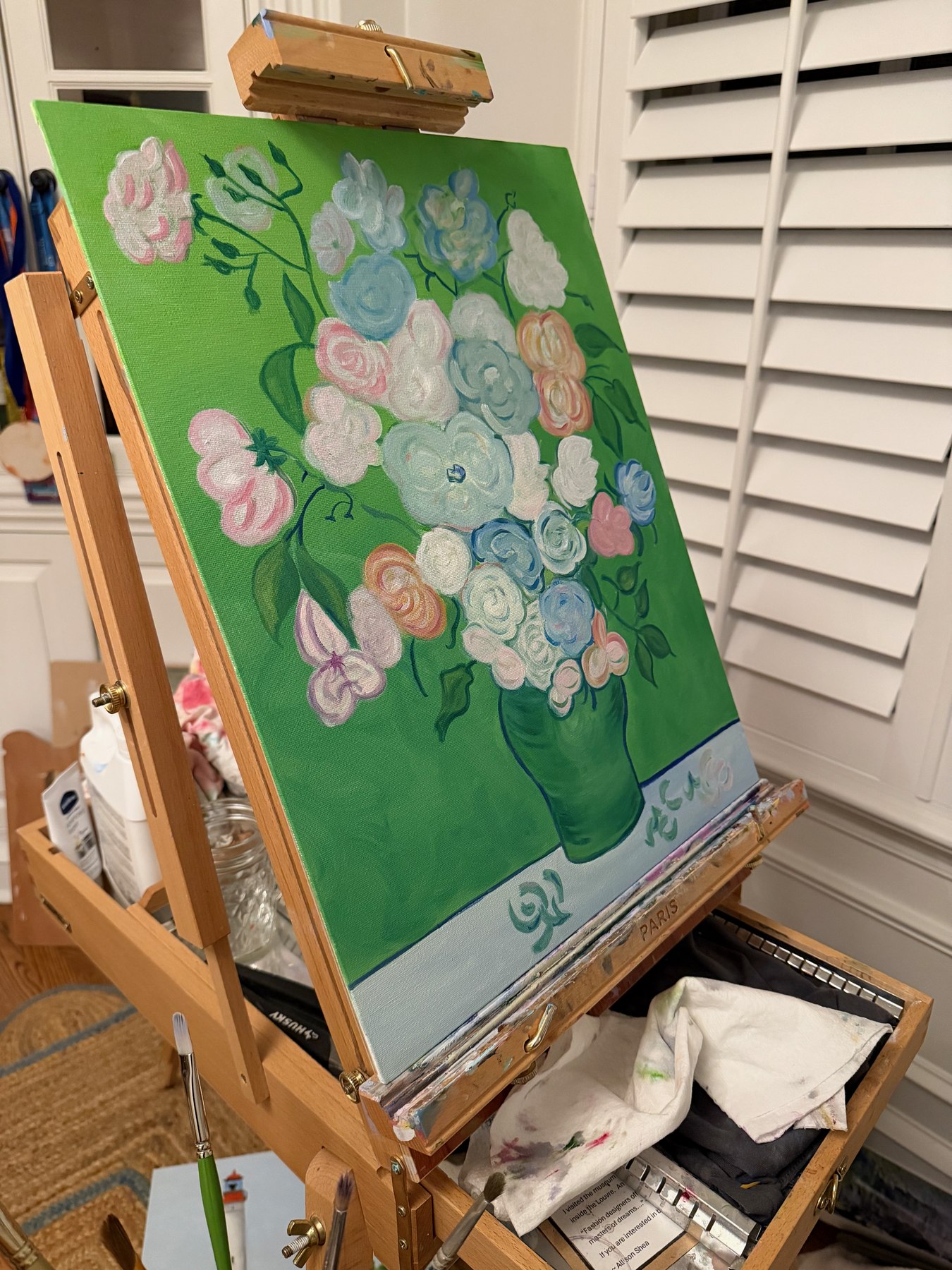 A floral oil painting in progress on the easel — green underpainting and bright florals taking shape in Allison Shea's studio